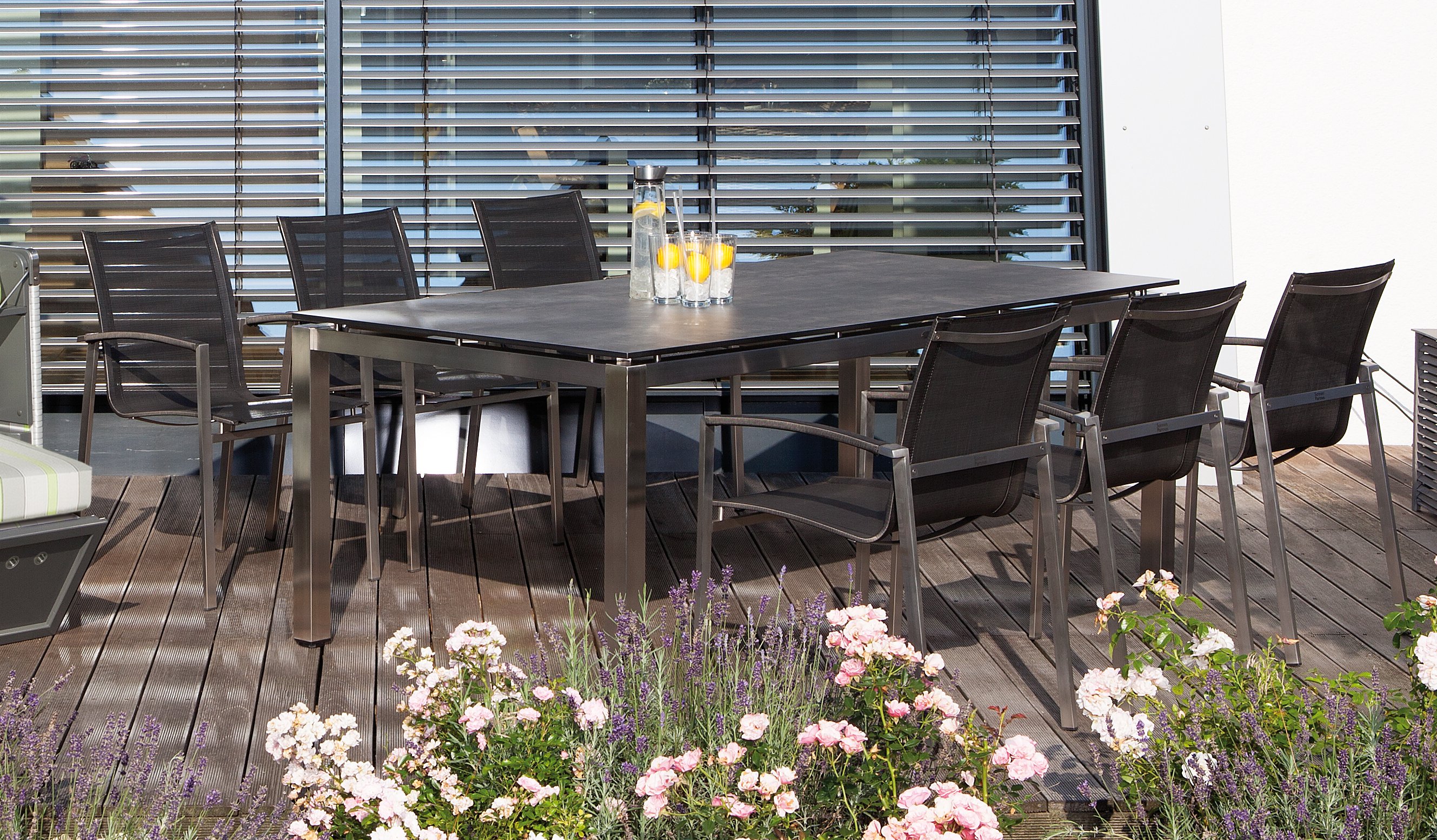 wetterfester Edelstahl-Terrassentisch mit stapelbaren Outdoor-Stühlen