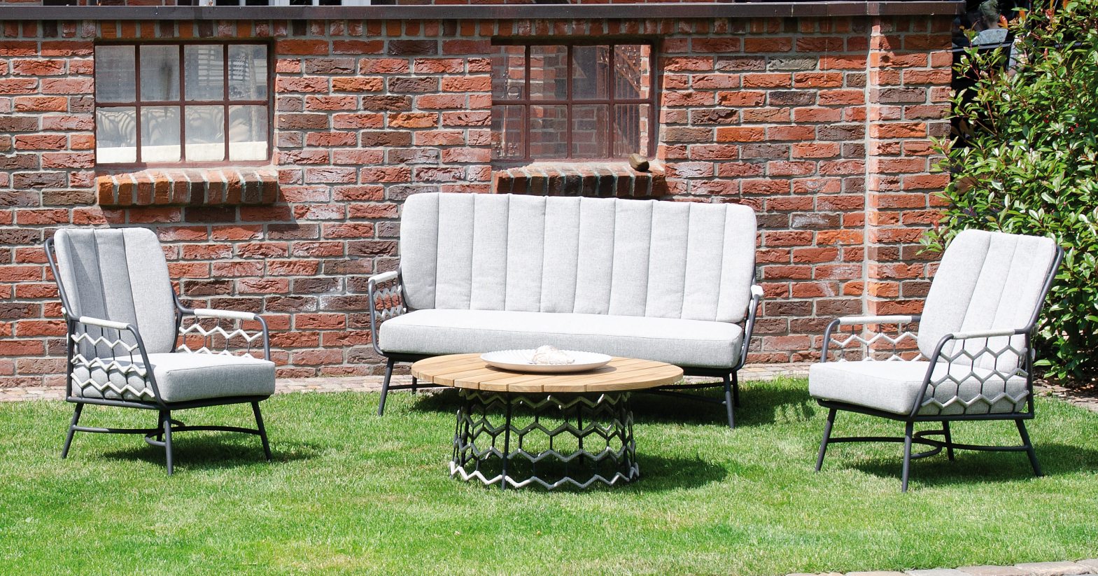 schöne bequeme Garten-Sitzgruppe mit hellen Polsterkissen