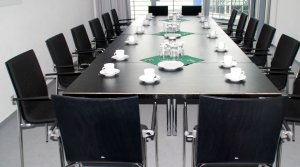 gepolsterter Konferenzstuhl mit Armlehnen und stapelbaren Vierfuß-Stahlgestell